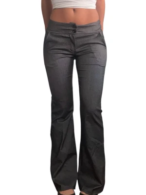 Kostymbyxor bootcut - Snygga kostymbyxor med bootcut-modell. Byxorna har två knappar framtill och lätt utsvängda ben. Midja: 33 cm rakt över Innerbenslängd: 75cm