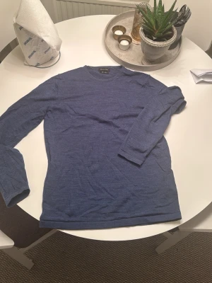 Blå stickad tröja Massimo Dutti - Säljer en stilren blå stickad tröja från Massimo Dutti i mjuk merinoull. Tröjan har rund halsringning och långa ärmar, perfekt för lager på lager. Enkel och klassisk design som passar till det mesta. ⚠️det finns ett litet lagat hål som man ser på sista bilden men de e iprinsip osynligt⚠️