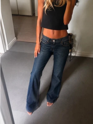 Mörkblå bootcut jeans - super snygga lågmidjade bootcut jeans. låset till dragkedjan har hoppat ut (bild 4) men borde gå att fixa lätt! W=25, L=34