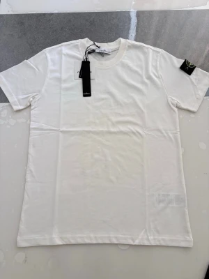 Stone island T-shirt - Hej! Säljer en jätte fin T-shirt som är i väldigt bra skick inga problem alls Väldigt fin till sommaren Storlek M (lite baggy, kan även passa L) Påse och tags ingår Skriv gärna vid intresse ❤️💯