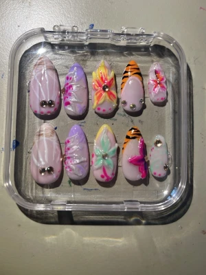 Somriga press on naglar - Säljer ett set press-on naglar i mandelform med 3d blommor och mycket färgglada mönster! Handgjorda och jätteroliga och unika!