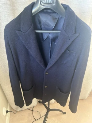 John Henric stickad blazer - En mörkblå stickad blazer ifrån John Henric i storlek M, perfekt för festligare tillfällen men även till vardags. Hör av dig vid frågor eller funderingar//