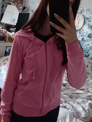 Rosa y2k hoodie  - Säljer en mjuk rosa hoodie i velour med dragkedja framtill och två fickor. Hoodien har huva med dragsko och ribbade muddar vid ärmar och nederkant. Ger en vintage y2k vibe. Har en liten fläck på ena ärmen som ev går bort i tvätten. Säljer en i blått också, båda för 120 kr. Pris kan diskuteras 💕