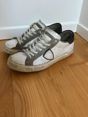 Vita Phillipe Model - Säljer ett par vita Phillipe Models, Storlek 41 med en skön look. Bra skick, bara ett hål på sulan, syns inget vid användning 