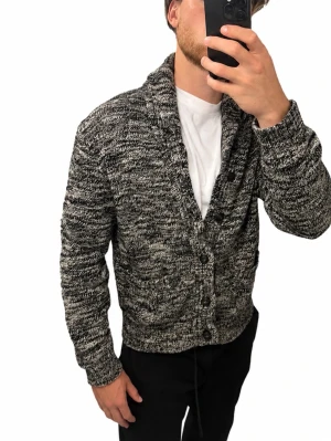 Cardigan Ralph lauren. Storlek L  - Polo Ralph Lauren stickad cardigan i storlek L. Klassisk modell i gråmelerad färg med sjalkrage, knappar framtill och två fickor. Snygg både öppen över en T-shirt och stängd under höst/vinter   Storlek: L Skick: Mycket fint skick Nypris: ca 2 000–2 500 kr Modellen är 186 cm lång. 