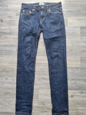 Mörkblå slim fit jeans - Snygga mörkblå slim fit jeans med klassisk femficksdesign och kontrastsömmar. Jeansen har normalhög midja och smala ben. Passar perfekt till en avslappnad streetstyle-look. Materialet är denim med stretch för extra komfort.
