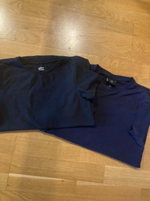 Två mörkblå t-shirts i bomull - Två stilrena mörkblå t-shirts med rund hals och korta ärmar. Båda är tillverkade i mjuk bomull och har en klassisk passform som funkar till det mesta. Perfekta basplagg för garderoben.