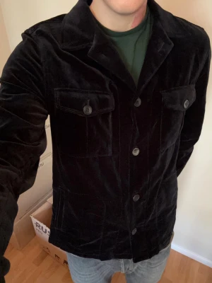 Svart ursnygg Oscar Jacobson overshirt L nyskick - Brutalt snygg sällsynt populär och eftertraktad svart Oscar Jacobson glänsande sammet overshirt i storlek L. Otroligt plagg i utmärkt nyskick och grym passform! Tveka inte vid minsta fråga eller fundering!
