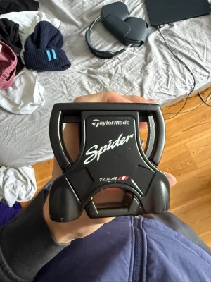 TaylorMade Spider putter - TaylorMade Spider putter med svart huvud och vit SuperStroke-grepp. Tour-modell med modern design och tydlig Spider-logga.