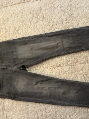 Grå slim fit jeans - Snygga grå jeans i slim fit-modell med lätt slitna detaljer och tvättad look. Jeansen har klassisk femficksdesign och smal passform längs benen. Perfekta för en avslappnad och trendig stil+ orginal pris 699kr
