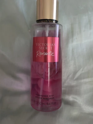 Victoria's Secret Romantic mist - Fräsch och feminin body mist från Victoria's Secret i doften Romantic. Flaskan är genomskinlig med rosa etikett och guldigt lock. Lite mer än halvfull. Perfekt för dig som gillar blommiga och mjuka dofter.