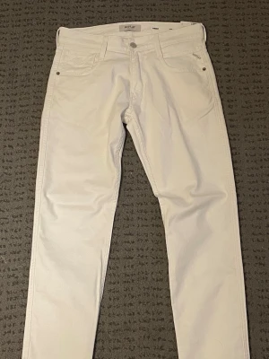 Replay Anbass White Jeans – Strl 30/30 - Säljer ett par Replay Anbass i vitt, storlek 30/30.  Jeansen är helt oanvända och kommer fortfarande med lappar, originalförpackning och skyddspåse. Säljs eftersom de tyvärr var lite för stora för mig, och det hann gå för lång tid innan jag kunde returnera dem.  * Märke: Replay * Modell: Anbass * Storlek: 30/30 * Färg: Vit * Skick: Nya, aldrig använda  Hör gärna av dig om du har frågor eller vill ha fler bilder! 😊