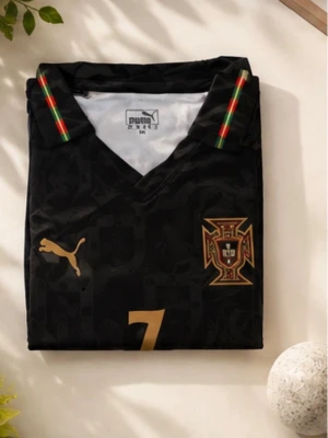 Svart Portugal fotbollströja - Snygg svart fotbollströja från Puma med Portugals landslagsemblem och nummer 7 i guld. Tröjan har korta ärmar, V-ringning och detaljer i grönt, rött och gult på kragen. Materialet är funktionsmaterial med DryCell-teknologi för att hålla dig torr.