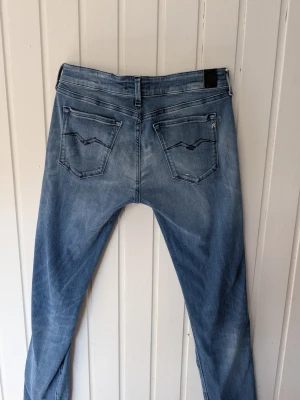 Blå jeans från Replay, modell Luz - Snygga blå jeans från Replay i modellen Luz. Jeansen har klassisk femficksdesign, raka ben och coola detaljer på bakfickorna. Tillverkade i mjukt denimtyg som sitter skönt och passar perfekt till din vardagsstil.