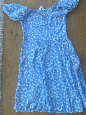 Holly & White mini klänning  - Fin nästan oanvänd kort klänning från Holly & White. Ljusblå med vita blommor. Är 160cm och klänningen slutar precis övsnför knäna 