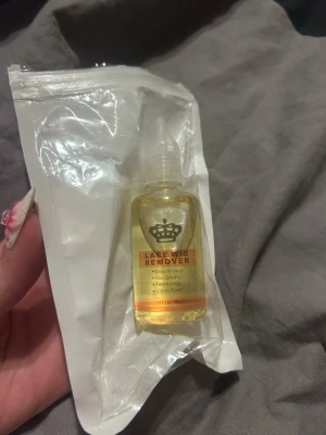 Lace Wig Remover citrusdoft - Lace Wig Remover i genomskinlig plastflaska med gul vätska. Produkten tar bort lim från lace wigs, är enkel att använda, fettfri och har en fräsch citrusdoft. Perfekt för dig som vill ta bort peruklim smidigt.