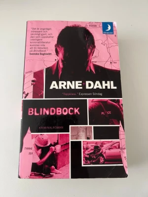 Blindbock av Arne Dahl - Kriminalroman av Arne Dahl i pocketformat från Månpocket. Omslaget är svart och rosa med collage av bilder och text. Boken är en del av serien om Opcop-gruppen och bjuder på spänning i Europa med teman som organiserad brottslighet och utpressning. Boken är mycket väl använd och man kan se skavanker på bilderna. 