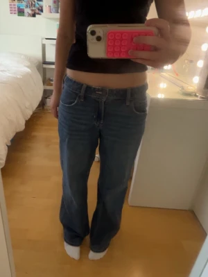 Blå low waist baggy jeans - Säljer ett par blå baggy jeans låg midja från Hollister. Storlek w27 och ”short” i längden vilket passar som l30 