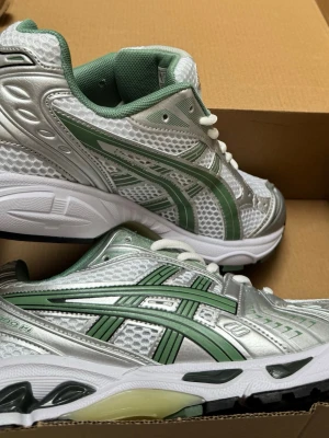 Asics silver och gröna sneakers - Snygga sneakers från Asics i silver och grönt med mesh- och syntetmaterial.