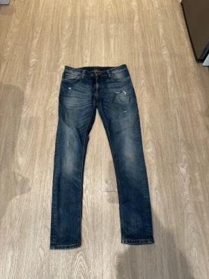 Nudie jeans  - Säljer ett par snygga blå Nudie jeans med små stilrena slitningar✌️ vid frågor eller funderingar är det bara att skriva😁