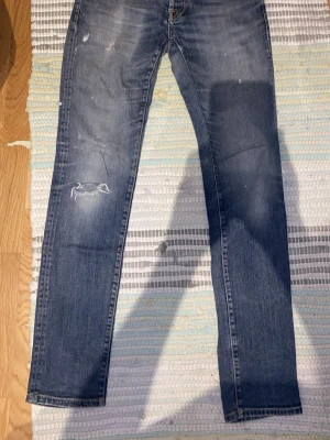 Morris jeans - Säljer ett par blå slim/ regular fit jeans från Morris med slitningar och snygga detaljer. Dom är gjorda på ett stretchigt material vilket gör dom jätte sköna att ha på sig! Dom är sjukt snygga som ”stackade” då dom ör rätt så långa. Dom är i bra skick borsätt ifrån att det är ett hål i höger fram ficka, det syns inte utanpå de går bara inte att ha något i den fickan. Priset är inte spikat!