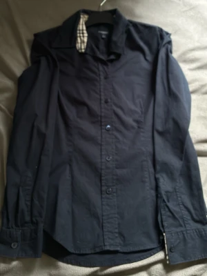 Mörkblå från Burberry  - Skjorta från märket, bra skick. Storlek är S fast hade sagt den sitter mer som XS . Priset är inte fast, skriv gärna vid frågor eller ifall du vill se mer bilder! Passar runt 170-175