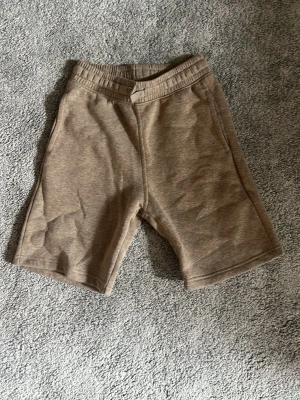 Beige shorts med resårmidja - Snygga och enkla beige shorts med resår i midjan och raka ben. Tillverkade i mjukt bomullsmaterial som känns skönt mot huden. Perfekta för varma dagar och en avslappnad stil.