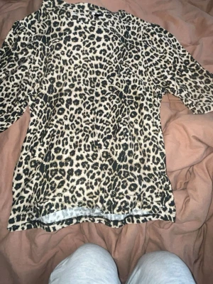 Leopardmönstrad topp XS - Säljer en leopardmönstrad topp i storlek XS från The Black Line Collection. Toppen har korta ärmar och är i mjukt material, perfekt för dig som vill sticka ut med ett djurmönster. Passar till många olika stilar och är superenkel att matcha.