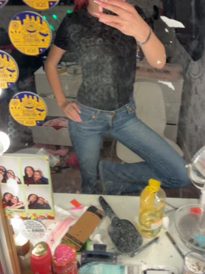 Blå bootcut jeans med låg midja - Säljer ett par klassiska blå bootcut jeans med låg midja och fem fickor. Jeansen har en snygg tvättad look och sitter tajt över höfterna innan de blir vidare nedtill. Perfekta för dig som gillar retrovibbar och vill ha ett par jeans som sticker ut.