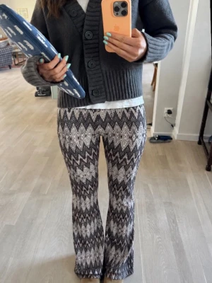 Mönstrade bootcut leggings - Säljer ett par snygga leggings med svartvitt zigzag-mönster och lätt utsvängda ben. Stretchigt material som sitter skönt och formar sig efter kroppen. Perfekta för dig som vill ha något unikt och trendigt i garderoben.