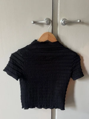 Svart croppad topp från H&M. - Säljer en svart croppad topp från H&M. Bra skick.💕