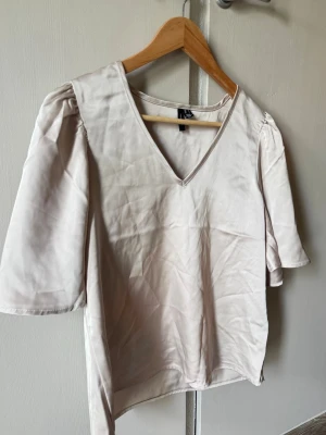 Ljusbeige sidenblus från VERO MODA. - Ljusbeige sidenblus med puffärmar från VERO MODA. Aldrig använt.💕