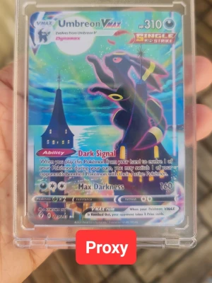 Pokémonkort Umbreon VMAX Proxy - Säljer ett färgstarkt Pokémonkort med Umbreon VMAX från Sword & Shield-serien. Kortet har holografisk yta och motiv av Umbreon mot en nattlig bakgrund. Engelskspråkig text och coola effekter som Dark Signal och Max Darkness. Perfekt för art decoration eller Pokémonfans.