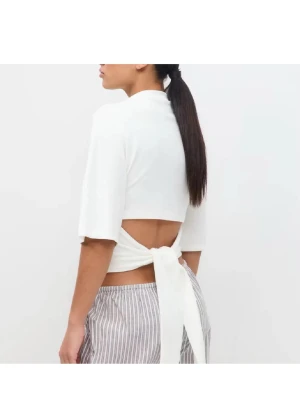 Vit topp med knyt i ryggen - Säljer en vit topp med halvlånga ärmar och snygg knytning i ryggen. Toppen har öppen rygg och är perfekt för dig som vill ha en trendig och stilren look. Tillverkad i mjukt material som känns skönt mot huden.