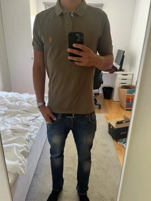 Olivgrön pikétröja från Ralph Lauren - Säljer denna riktigt snygga piké från Ralp Lauren, den är i relativt bra skick med lite små slitningar.
