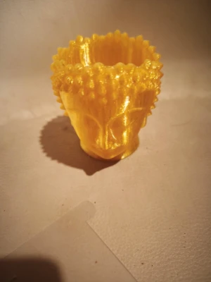 Gul Buddha-huvud kruka i plast - Unik liten kruka i form av ett Buddha-huvud, tillverkad i gul, glansig plast. Perfekt som dekoration eller för små växter. Detaljerad design med tydliga ansiktsdrag och struktur på håret. Ger ett färgstarkt och spirituellt intryck i rummet.