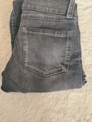 Grå bootcut jeans med slitningar - Säljer ett par gråa bootcut jeans. Jeansen har en lätt tvättad look och markerade sömmar. Perfekta för dig som gillar en avslappnad men trendig stil. Strl 152💕