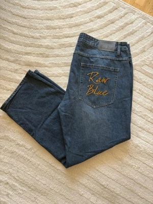 Baggy / streetwear jeans  - Vintage Raw Blue Premium RB Jeans – Y2K / 90s / 00s. Snygg klassisk baggy fit med broderad Raw Blue-logga på bakfickan. Mycket fint skick. Storlek - W40/L32. 