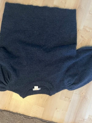Mörkblå stickad tröja Gina Tricot - Mysig mörkblå stickad tröja från Gina Tricot med rund halsringning och puffiga ärmar. Tröjan är i ett mjukt material och har en enkel, stilren design som passar perfekt till jeans eller kjol. Tar alla bud!