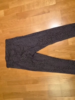 Stronger byxor - Snygga svarta leggings med grått leopardmönster. De har en tight passform och är perfekta för dig som gillar djurmönstrat. Mjukt och stretchigt material som sitter skönt hela dagen. 