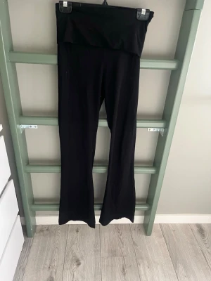 Svarta utsvängda leggings - Säljer ett par svarta leggings med hög midja och utsvängda ben. De är stretchiga och mjuka, perfekta för en chill och avslappnad stil. Passar till både sneakers och boots. Materialet känns som bomull eller en bomullsblandning.