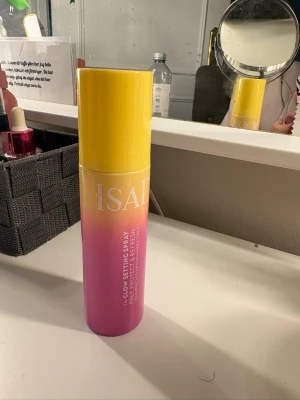Isadora Glow Setting Spray  - Glow Setting Spray face mist från ISAD i en snygg gul till rosa ombre-förpackning. Perfekt för att fräscha upp och ge glow till huden. Sprayflaskan är rund och smidig att ta med i väskan. Bara provad 1 gång 