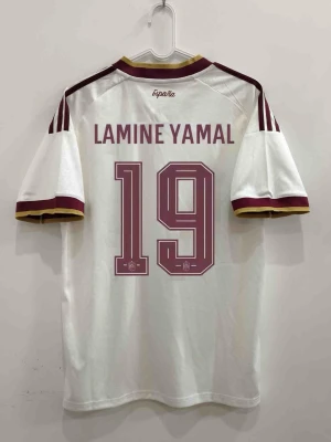 Vit Spanien fotbollströja Lamine Yamal #19 - En vit fotbollströja från Spanien med vinröda detaljer och texten 'LAMINE YAMAL' samt nummer 19 på ryggen. Tröjan har vinröda och gula ränder på ärmarna och klassisk sportig passform. Perfekt för dig som älskar fotboll och vill stötta landslaget.