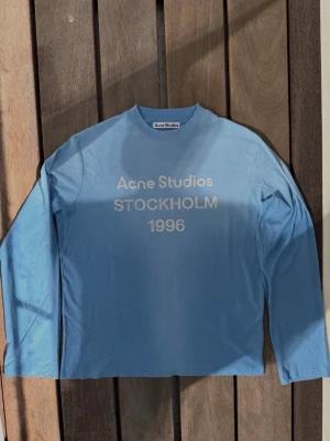 Acne Studios 1996 Stockholm logo Longsleeve  - Acne Studios 1996 Stockholm logo Longsleeve | Helt babyblå färg med slitna detaljer över hela tröjan | Den här är från den nyaste säsongen, en av de bästa färgerna | Superbekväm och bra kvalitet, perfekt till sommaren | Storlek XS Herr eller S Dam, passar oversized | Superfin passform generellt | Inga defekter, fläckar eller hål | Vid fler frågor/bilder är det bara och höra av sig