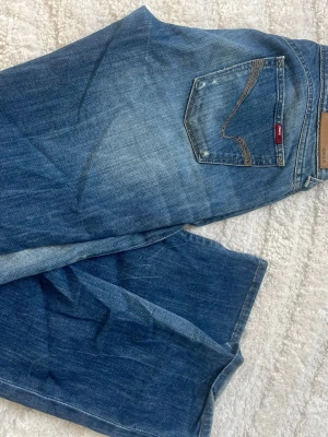 Vintage jeans - Snygga blå jeans med raka ben och slitna detaljer. Jeansen är vintage och lågmidjade. Super coola som höjer outfiten. W30 och L34