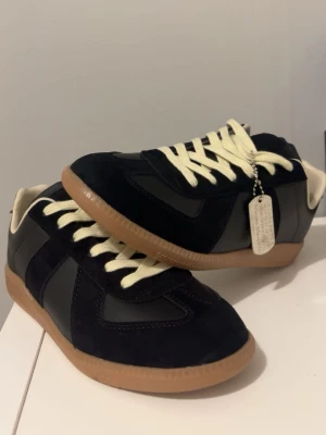 Svarta sneakers med beige sula. Rep!! - Stilrena svarta sneakers med beige gummisula och vita snören. Ovandelen är i en mix av mocka och slätt läder för en schysst kontrast. Låg modell som passar till det mesta och ger en clean look.