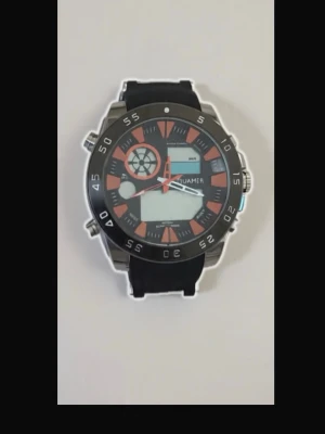 Svart och orange sportig klocka - Säljer en sportig klocka med svart och orange urtavla och svart armband. Klockan har digital display, tydliga siffror och flera knappar på sidan. Boetten är i silverfärgad metall och armbandet är i slitstark syntet. Perfekt för dig som gillar en cool och modern stil.