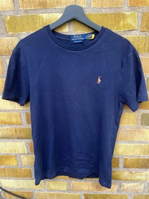 Polo Ralph Lauren t-shirt i mörkblått - En riktigt snygg mörkblå T-shirt från Ralph Lauren. Hör gärna av er!