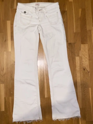 Vita low waist bootcut jeans - ordinarie pris 700kr, säljer för 300 Vita låg midjade jeans från Nelly, Inga tydliga tecken på användning, Hänger flisor vid fötterna, går att klippa bort ifall man inte gillar det, Dessa byxor är anpassade för kortare ben🤍
