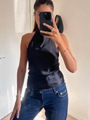 Svart halterneck topp i satin - Säljer en svart halterneck topp i satinmaterial från Zara! Toppen är helt ny, aldrig använd, perfekt som en festtopp! 🕺🏻🖤